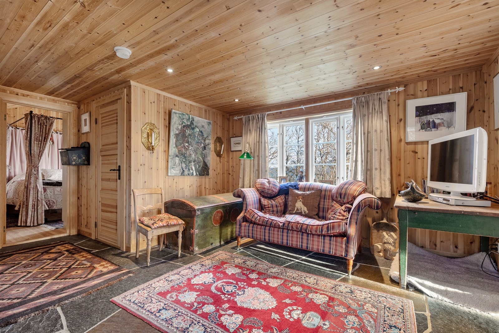 Her blir du ønsket velkommen inn i en stor og innbydende entré, med gulv av skifer og trepanel på veggene. Galleribilde