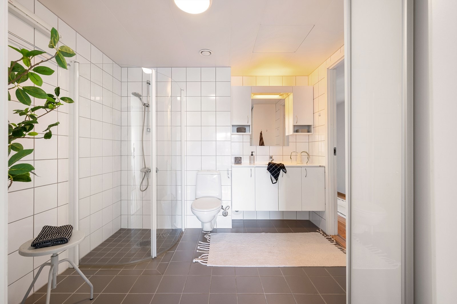 Rommet er innredet med vegghengt klosett, servant med innredning og dusjhjørne med glassdører. Det er inngang til bad både fra gang og hovedsoverom. Galleribilde