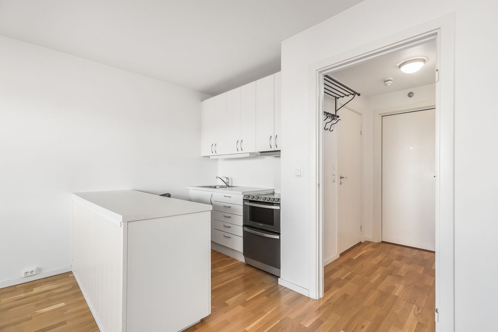 Kjøkken med oppvaskmaskin, kombiskap og komfyr. Bar løsning som fungere som spisebord. Galleribilde