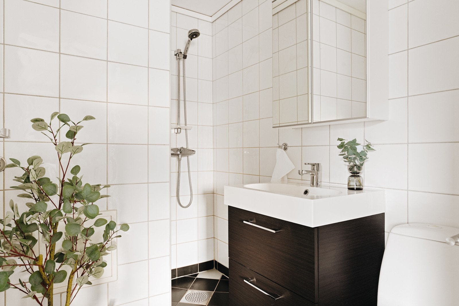 Badet måler ca. 2,6 kvm, er helfliset og har en slett malt himling. Det er innredet med dusjnisje, opplegg for vaskemaskin, toalett og baderomsinnredning. Galleribilde