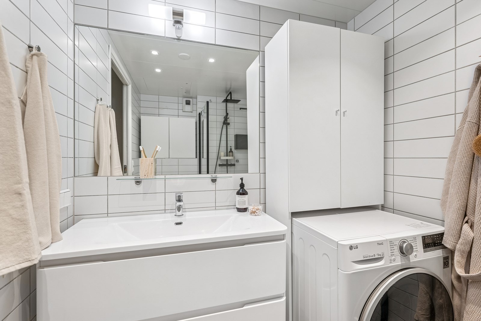 Badet har praktisk innredning med rikelig av oppbevaringsplass, samt opplegg for vaskemaskin. Galleribilde