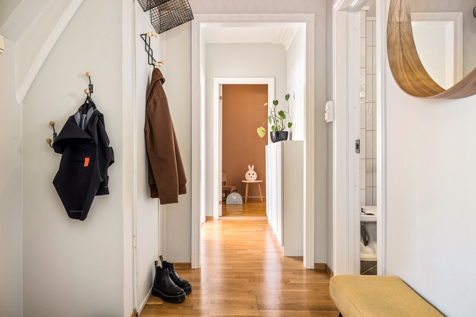 Lys entré med plass til oppheng av tøy og et lite skap for annen oppbevaring. Her får man også tilgang til bod under trapp. Galleribilde