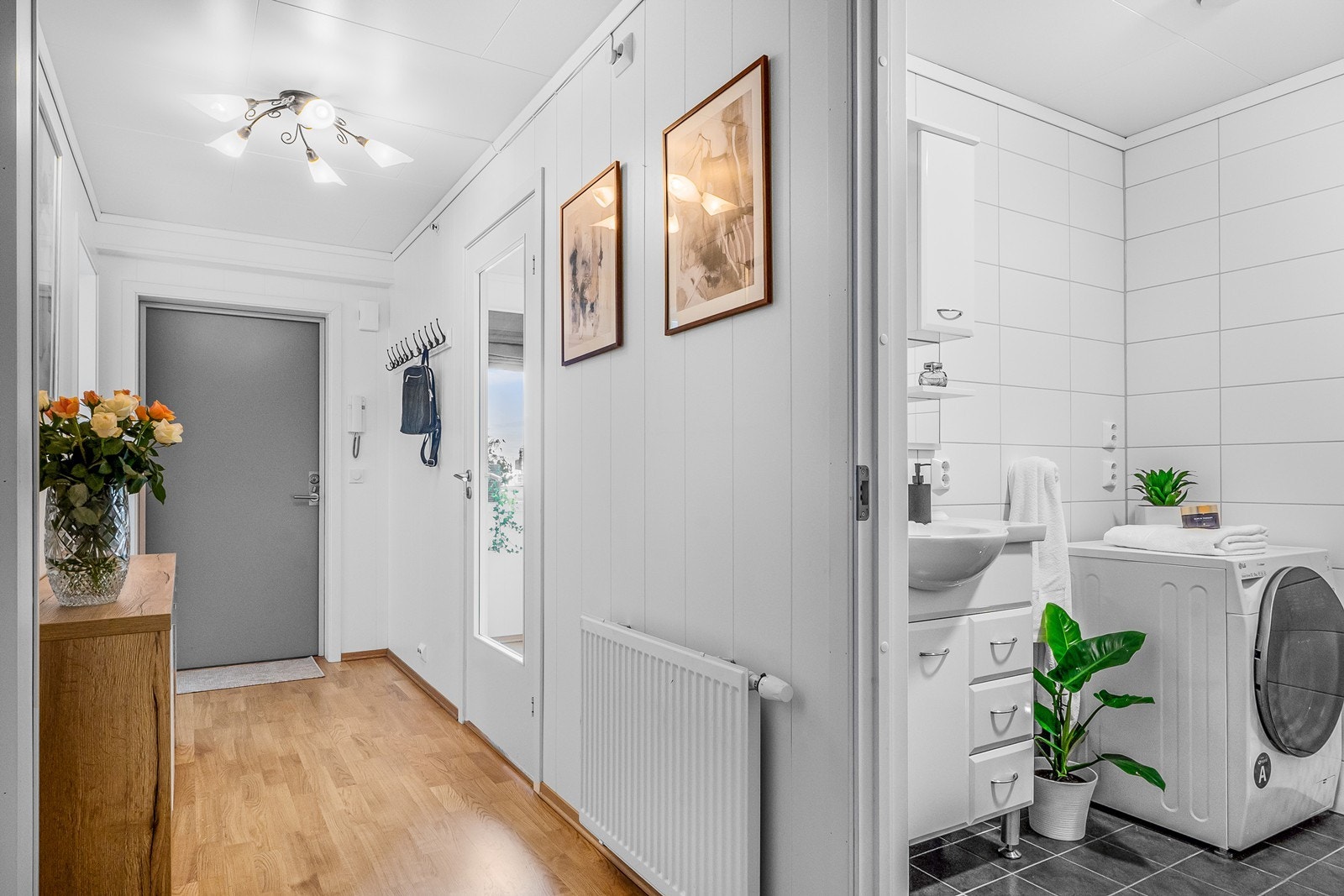 Vel inne er en lys entré med plass til garderobemøbel og knagger til yttertøyet. Galleribilde