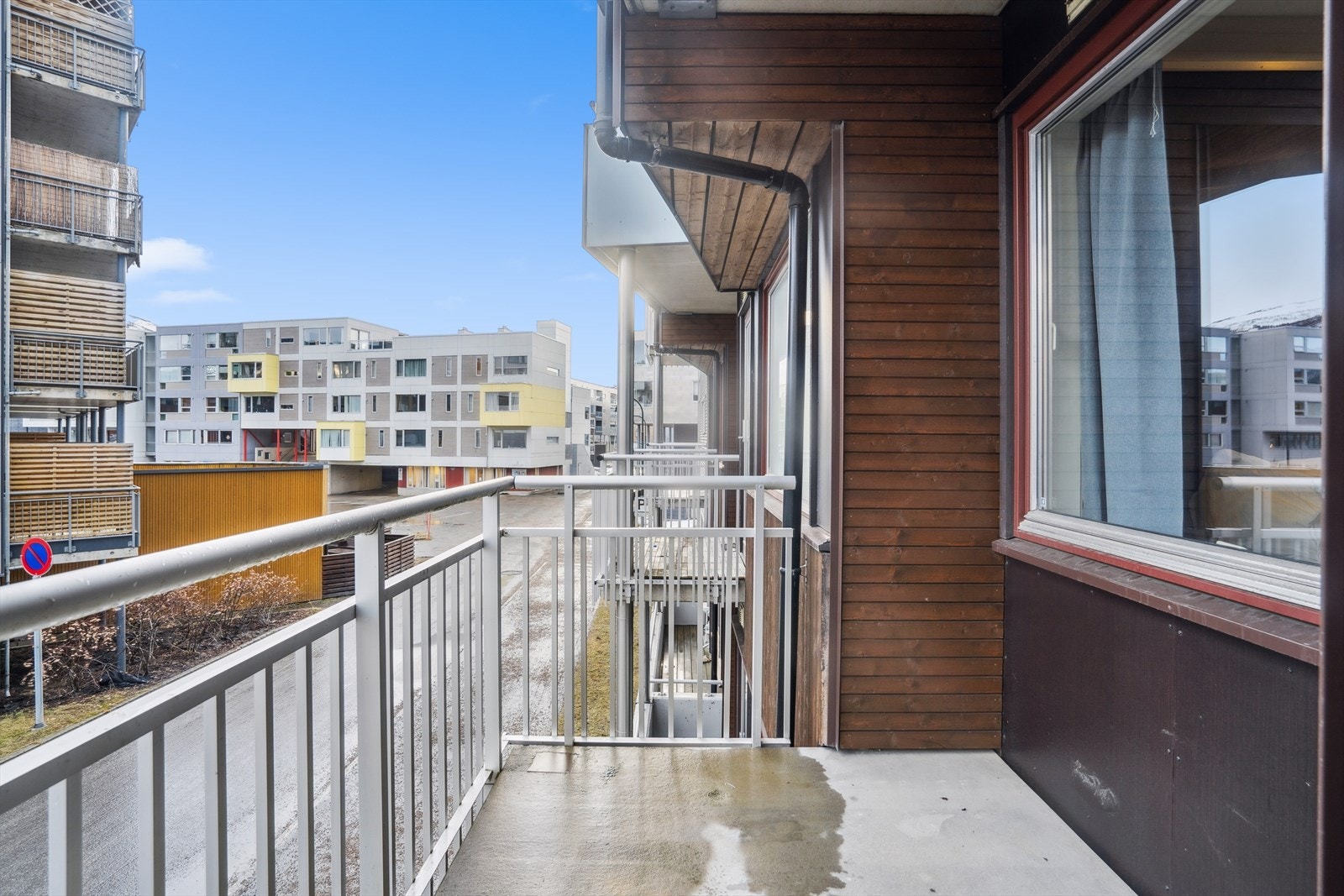 Morgen og formiddagssol fra egen balkong. Du kan se Tromsøysundet litt mellom boligblokker i front. Galleribilde