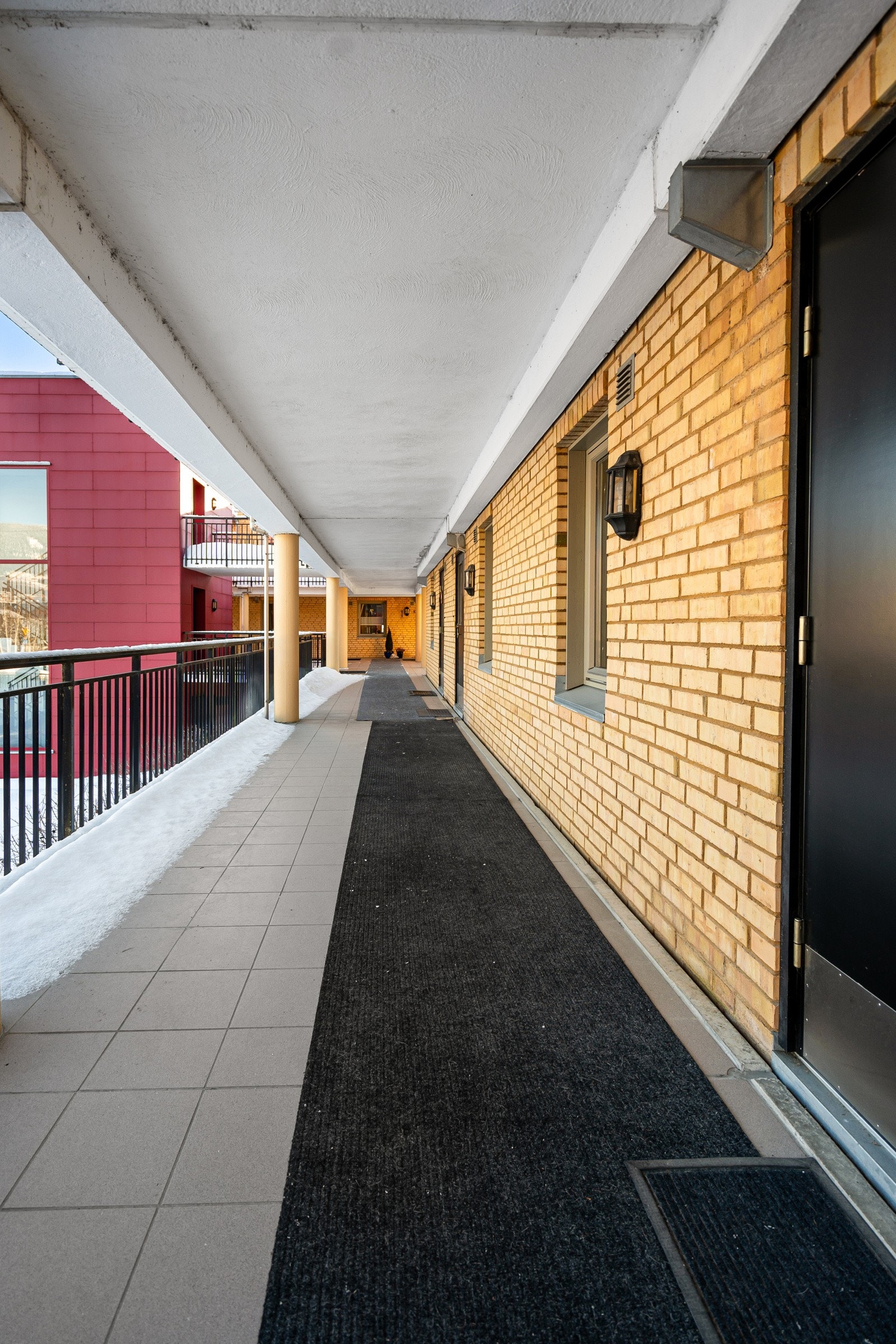 Bred svalgang ved inngang til leiligheten. Galleribilde