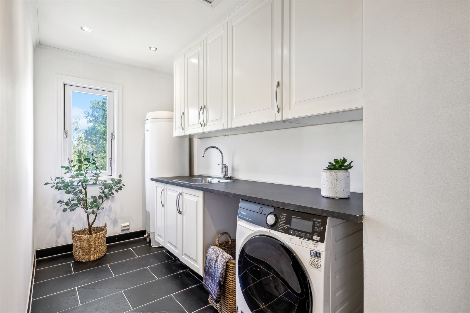 Vaskerommet har flislagt gulv med varmekabler, malte veggoverflater, oppusset i 2013 og er utstyrt med innredning, laminat benkeplate med utslagskum og opplegg for vaskemaskin. Galleribilde