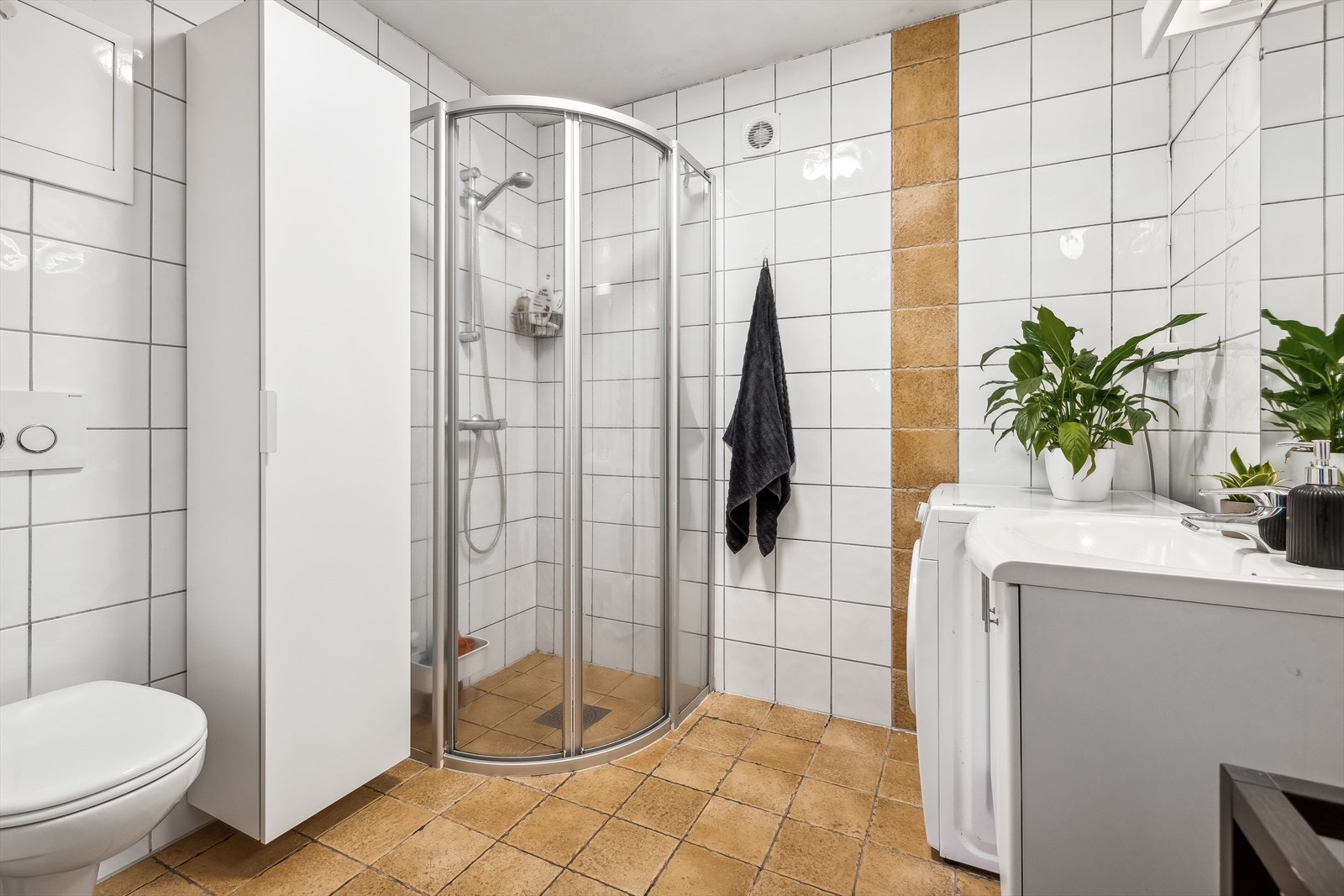 Flislagt baderom med gulvvarme og opplegg for vaskemaskin. Galleribilde