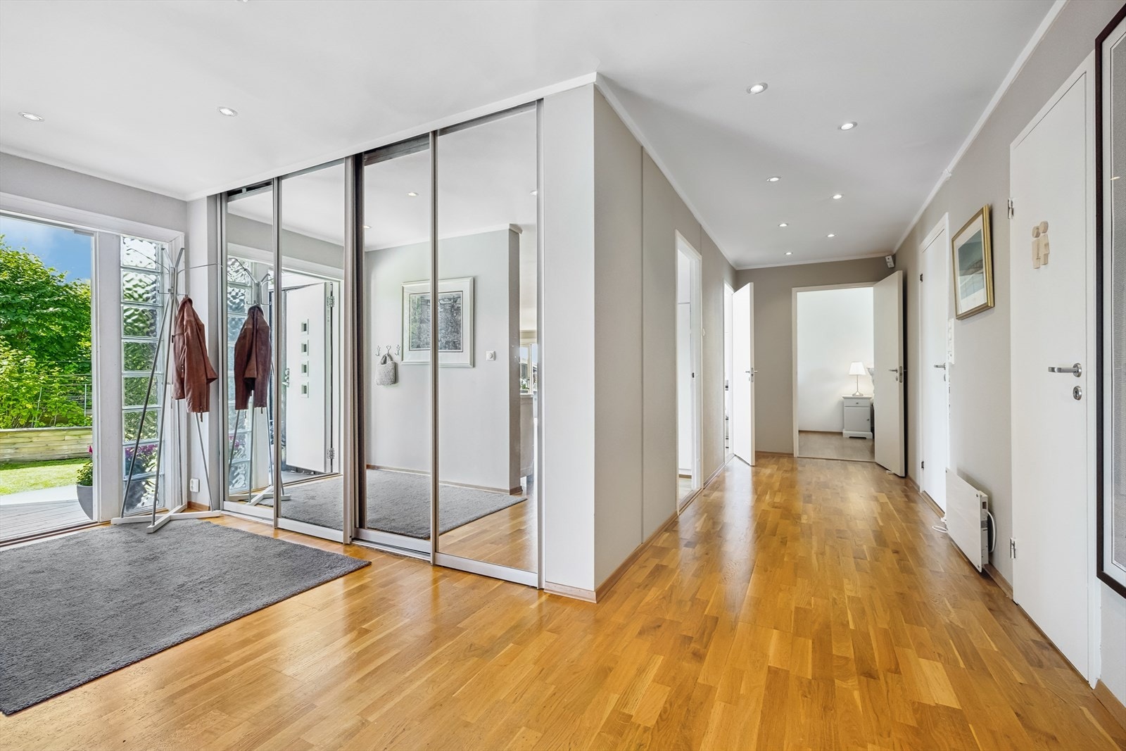 Det er god plass til oppbevaring av ytterklær og sko i et stort garderobeskap med skyvedører av speil. Galleribilde