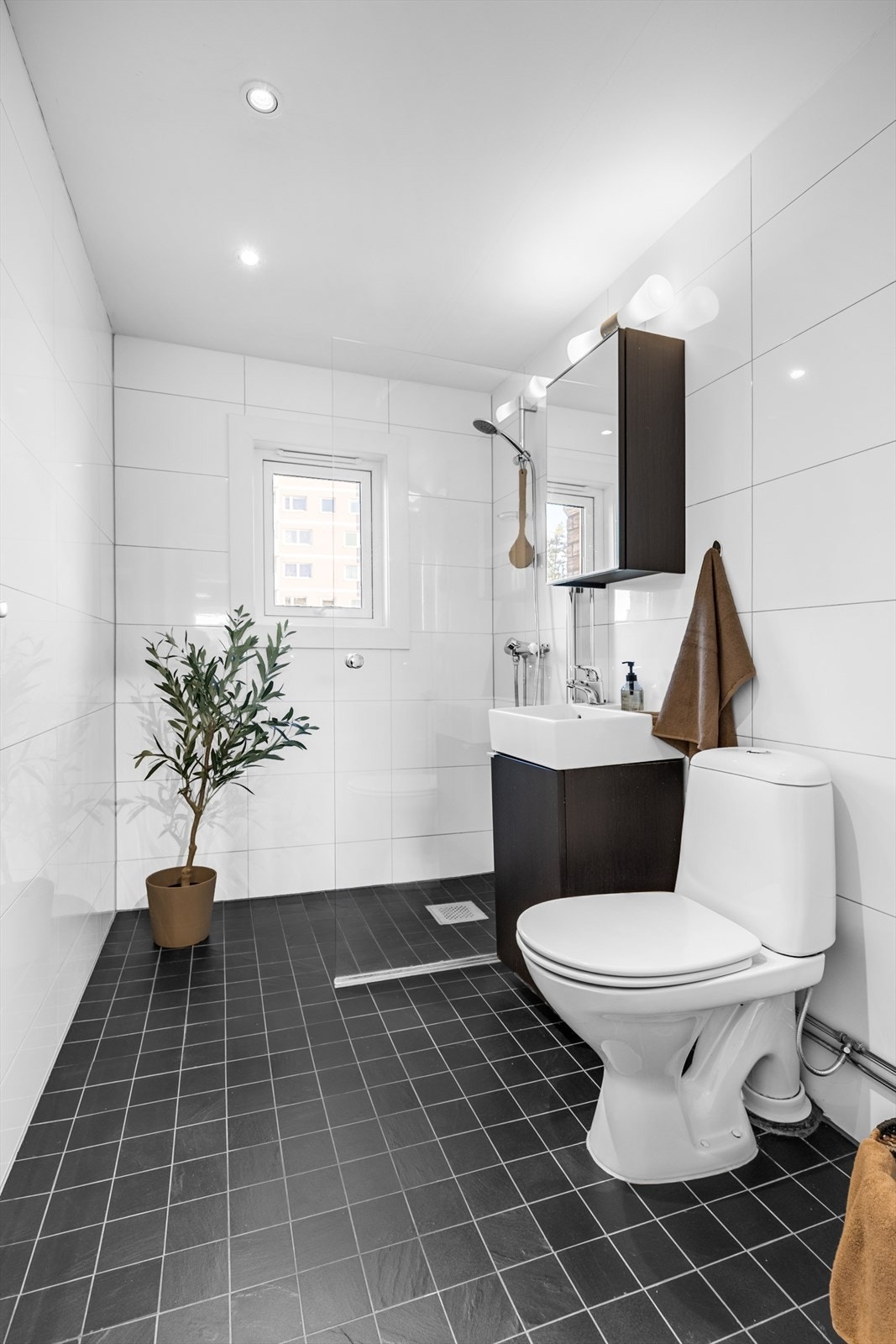 Badet er utstyrt med dusjhjørne med vegg i herdet glass og downlights i himling. Opplegg for vaskemaskin. Galleribilde