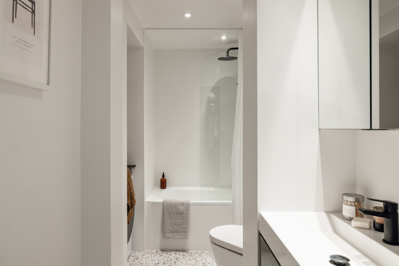 Elegant baderom med behagelig gulvvarme, downlights i taket og god funksjonalitet. Nisje med plass til både vaskemaskin og tørketrommel til venstre i bildet. Galleribilde