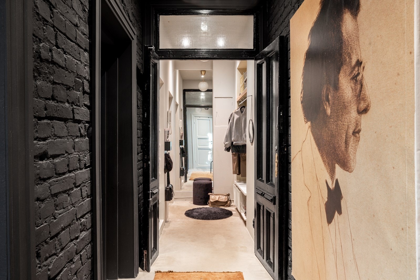 Velkommen inn til en romslig entré med mye smart oppbevaringsplass til klær og sko. Eier har satt inn en klassisk, dobbel fløydør som kompletterer den klassiske stilen samtidig som fargen sort både på døren og teglsteinen utfordrer! Galleribilde