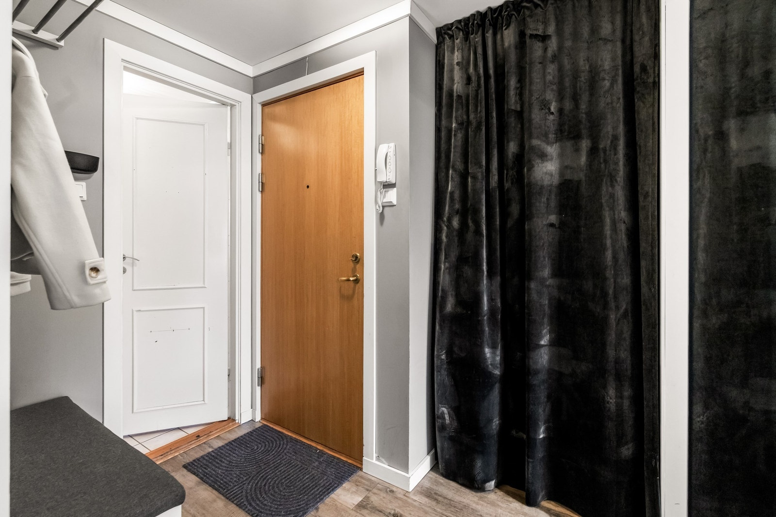 Entrè med plass til å henge av yttertøy. Vaskemaskin er plassert bak forheng (med aquastop). Porttelefon Galleribilde