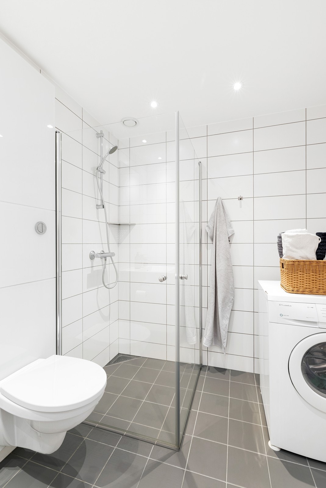 Bad med dusjkabinett, servant, vegghengt wc og opplegg for vaskemaskin Galleribilde