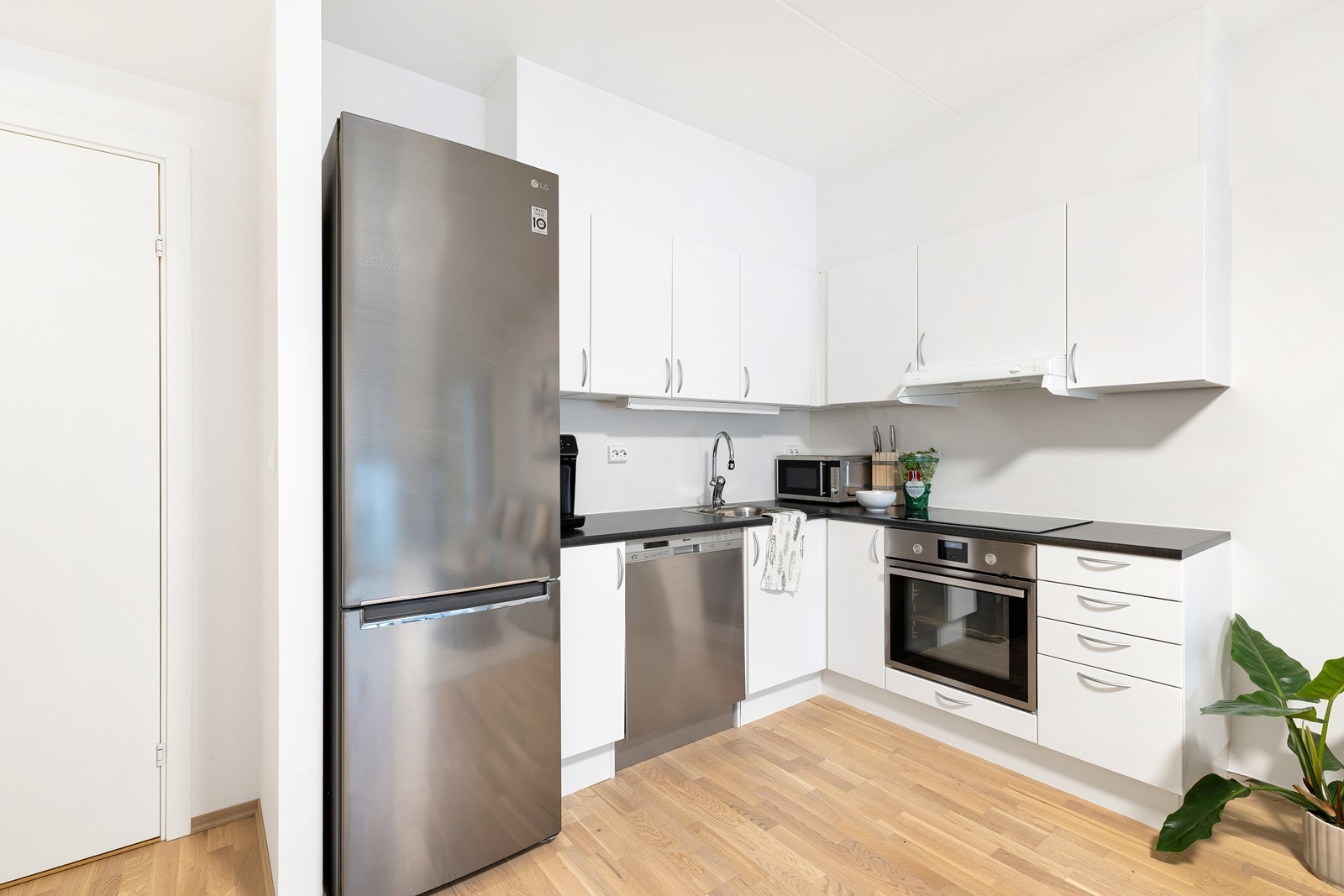 Pent kjøkken som inneholder komfyr, oppvaskmaskin og kjøleskap Galleribilde