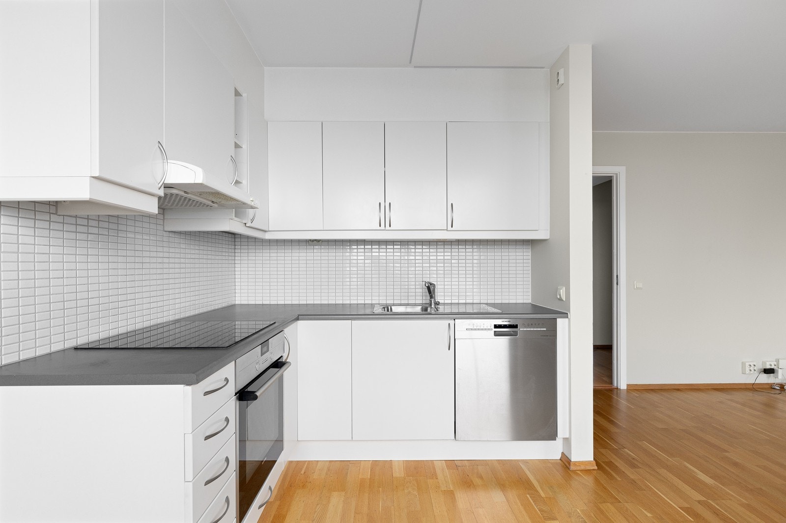 Kjøkken med god benkeplass, hvitevarer og praktiske løsninger for både matlaging og oppbevaring Galleribilde