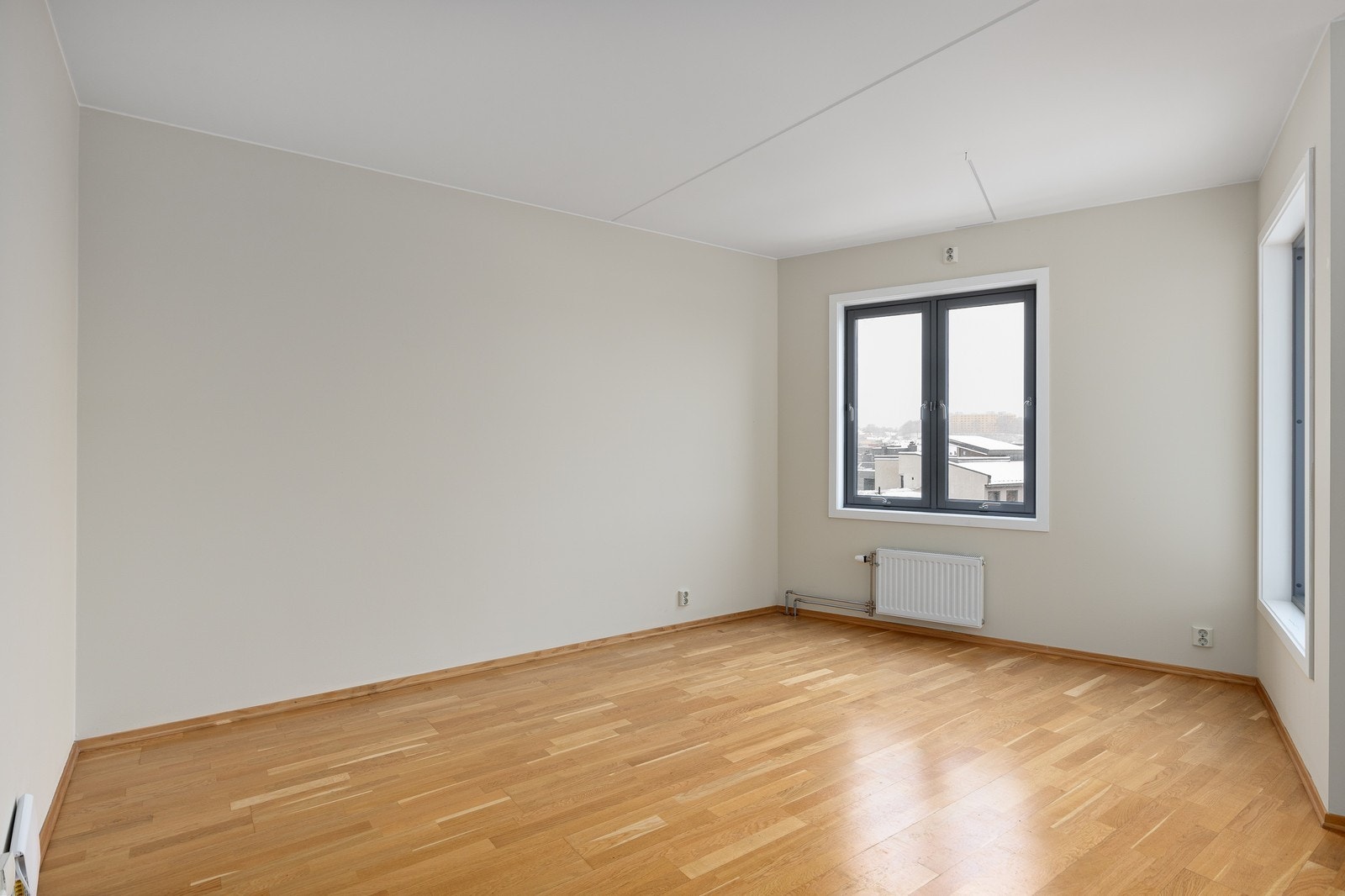 Stue med store vinduer som gir rikelig med lysinnslipp og skaper en lys og luftig atmosfære Galleribilde