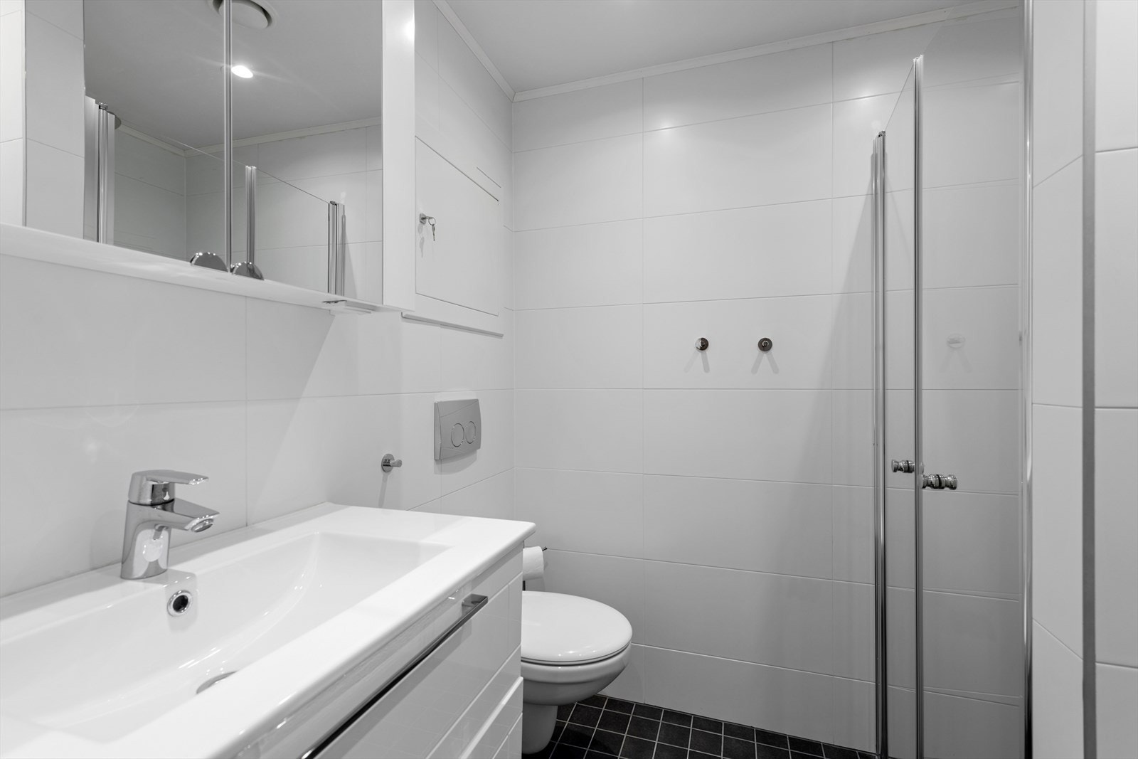 Lyst, flislagt bad med servantinnredning med skuffer, samt overskap med speilfronter.
Bildet er fra tilsvarende leilighet, bare speilvendt. Galleribilde