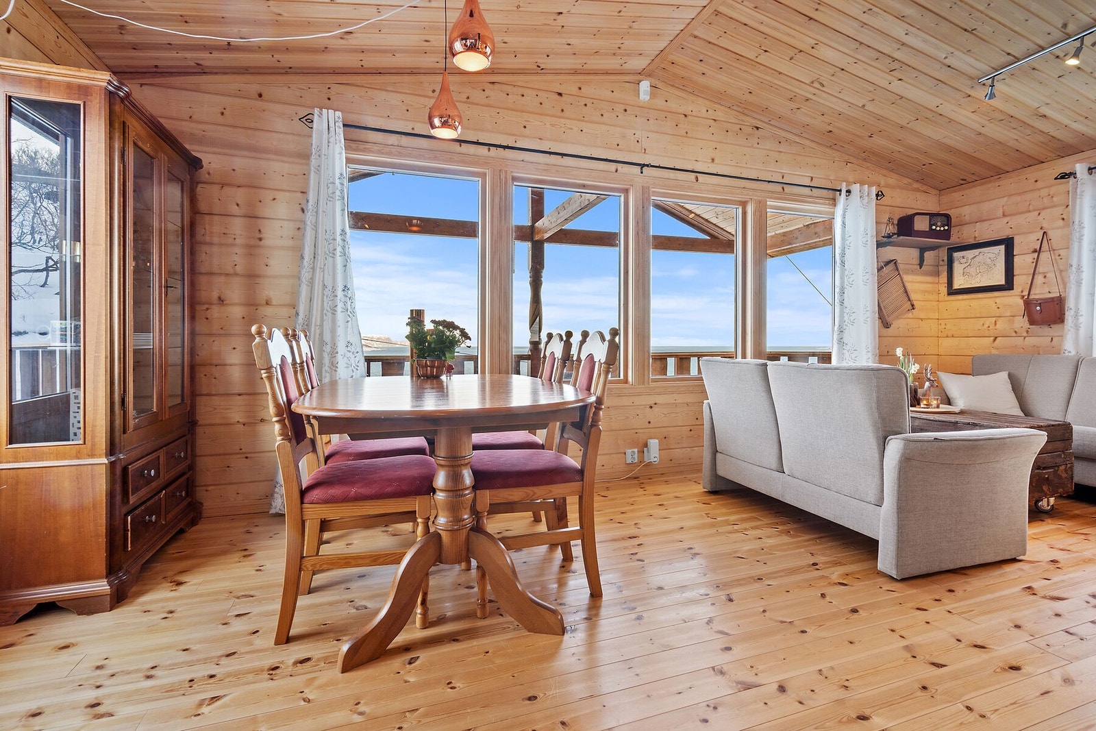 Stue - Romslig og åpen stue med spisebord, sofahjørne, god takhøyde, samt mange vinduer for å nyte den flotte utsikten! Galleribilde