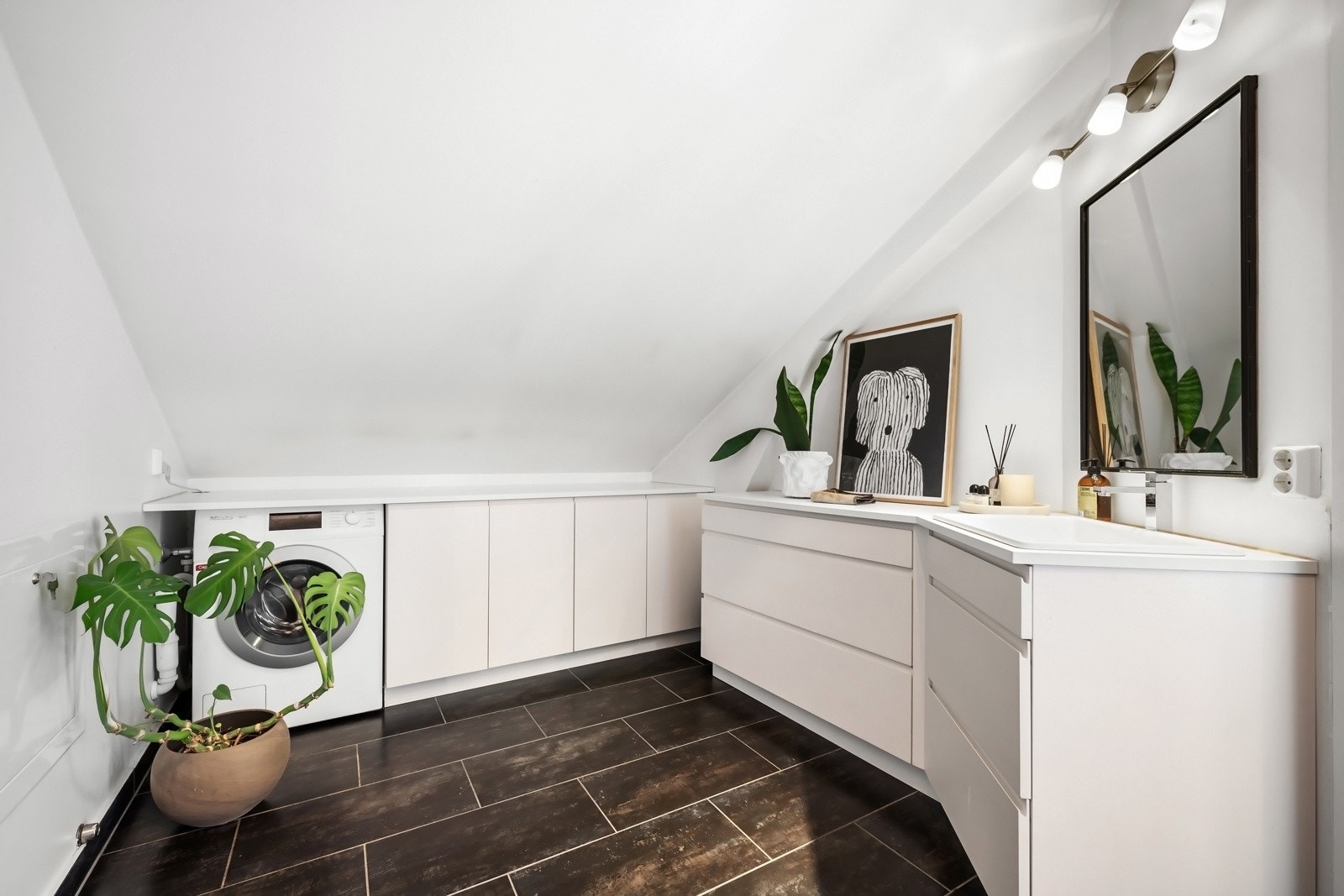 På badet er det også opplegg for vaskemaskin. Det er plassbygget innredning som gir ekstra lagring. Galleribilde