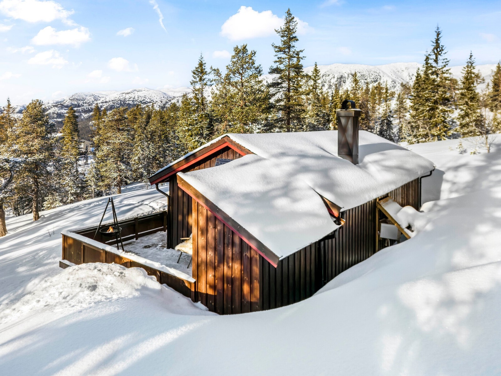 Hytta ligger fint til i skogsterreng Galleribilde