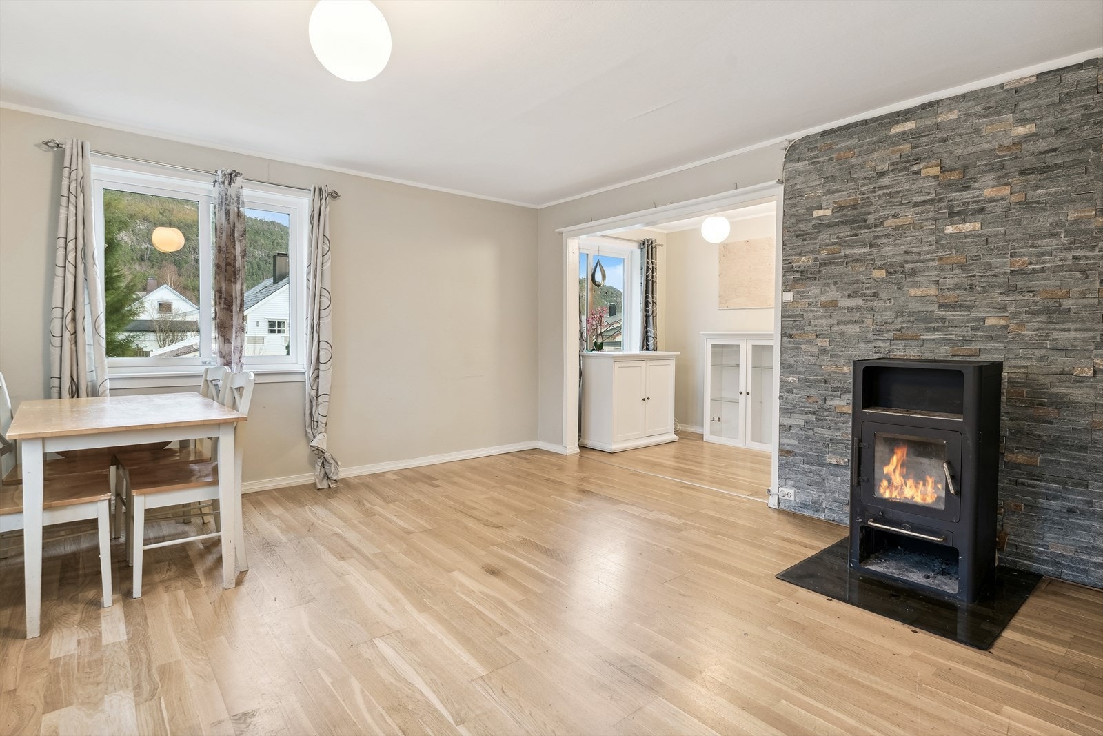 Stove i 1.etasje med parkett på golv. Vedomn med steinfliser i bakkant. Galleribilde