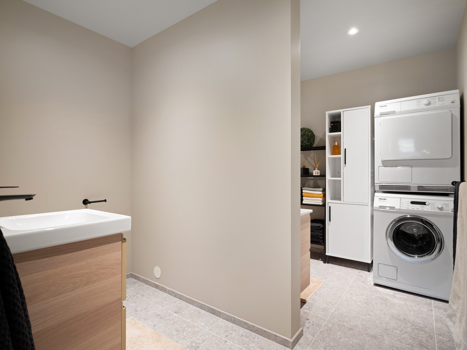 Badet er delt i to soner med vegghengt toalett på den ene siden og dusj på den andre Galleribilde