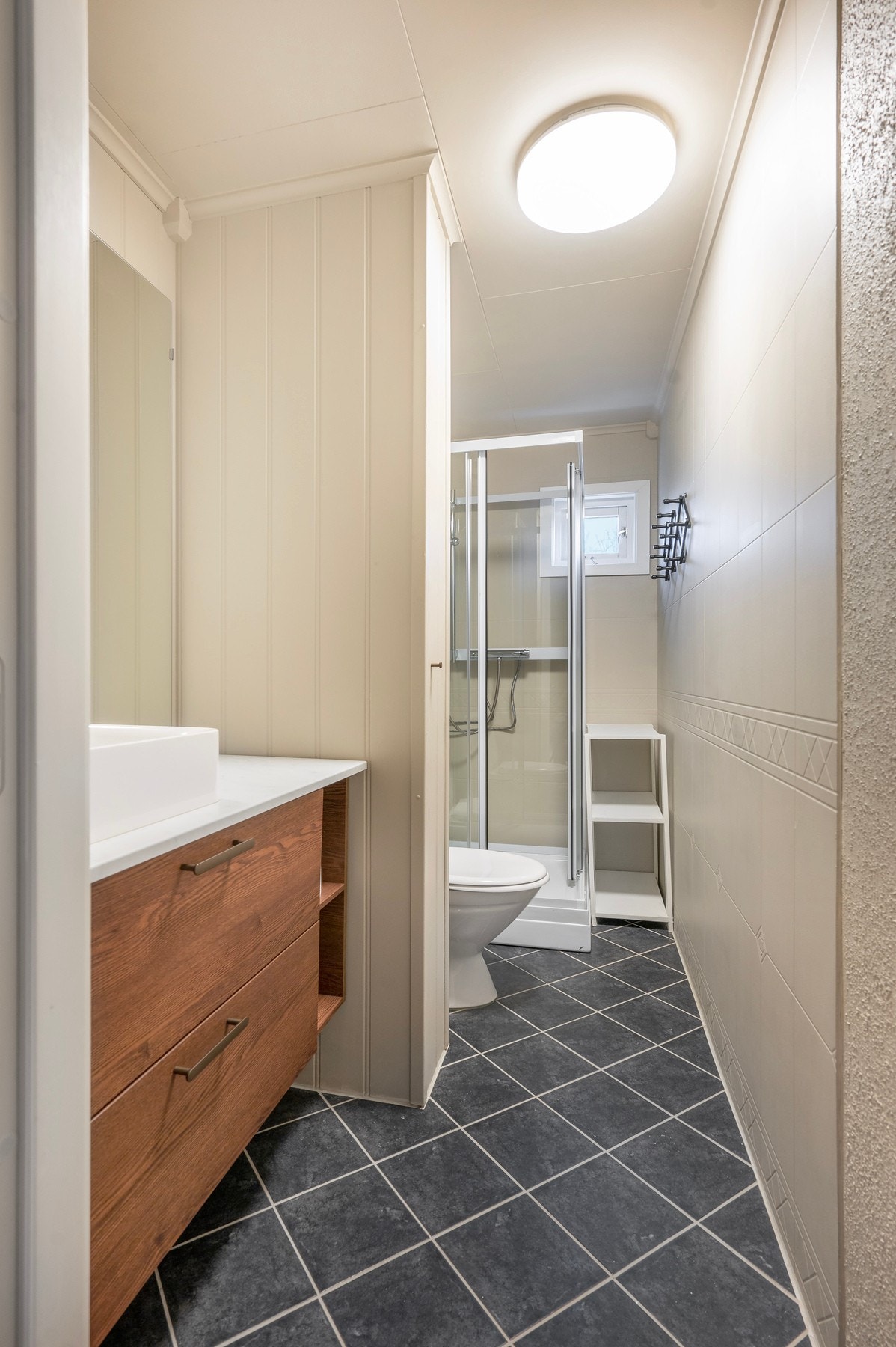 Flislagt baderom med malte våtromsplater på veggene. Galleribilde