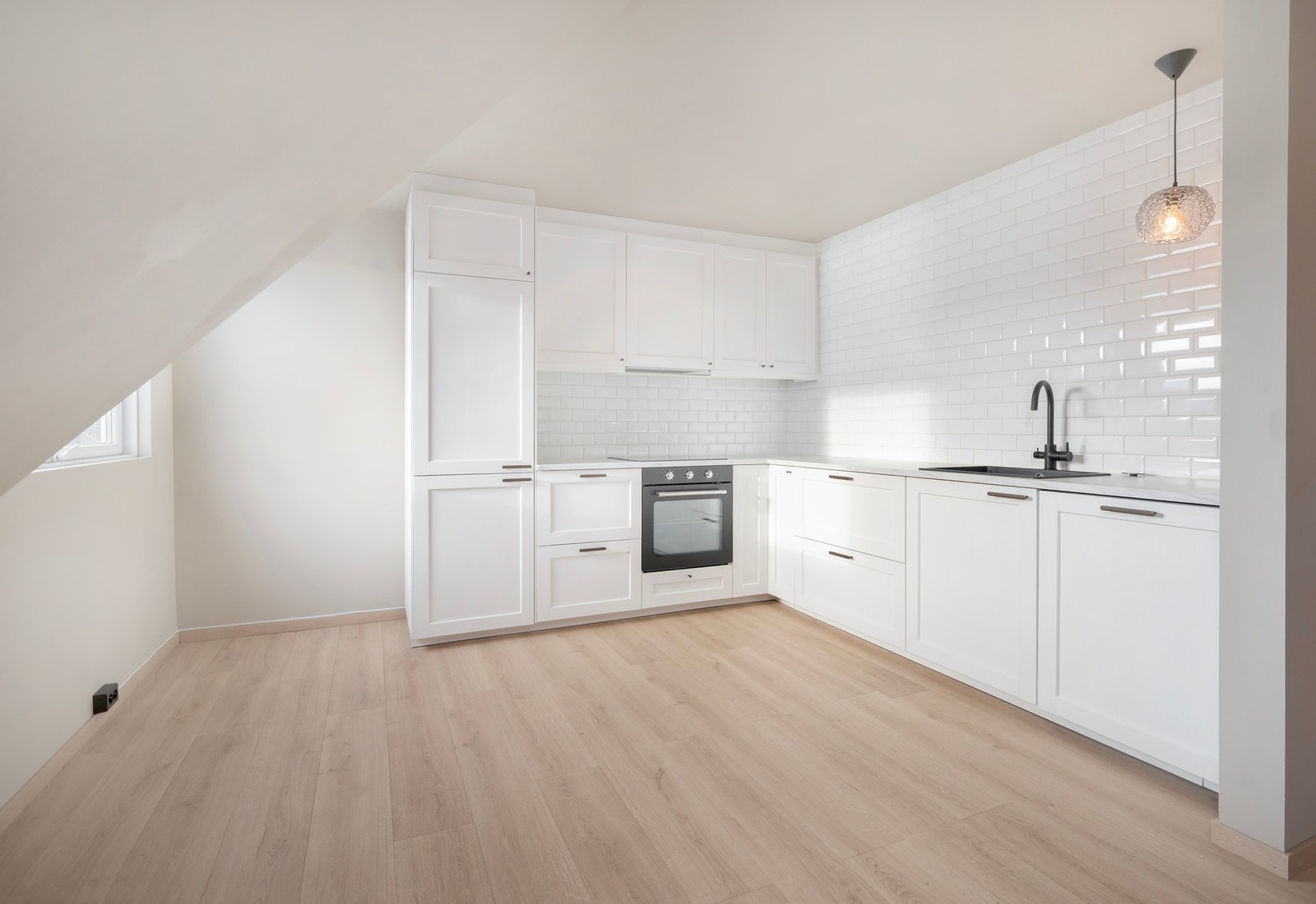 Det er en åpen løsning mellom stue og kjøkken. Galleribilde