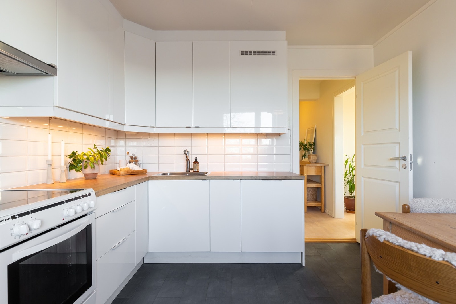 Benkeplaten i laminat har en nedfelt oppvaskkum, og flislagt vegg over benken gir et stilrent preg. Galleribilde