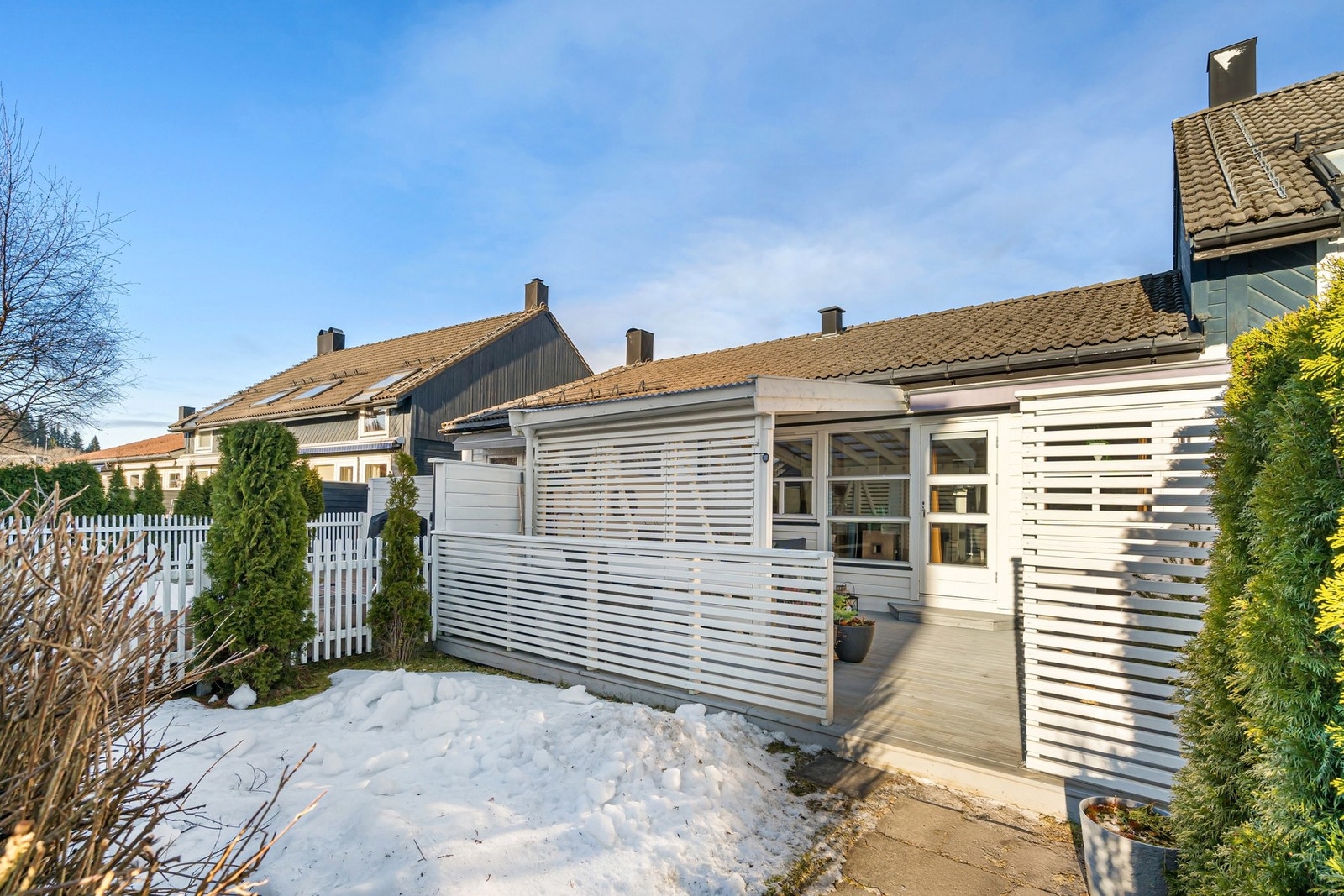På fremsiden av huset har man en sørvendt terrasse samt en koselig hageflekk. Galleribilde