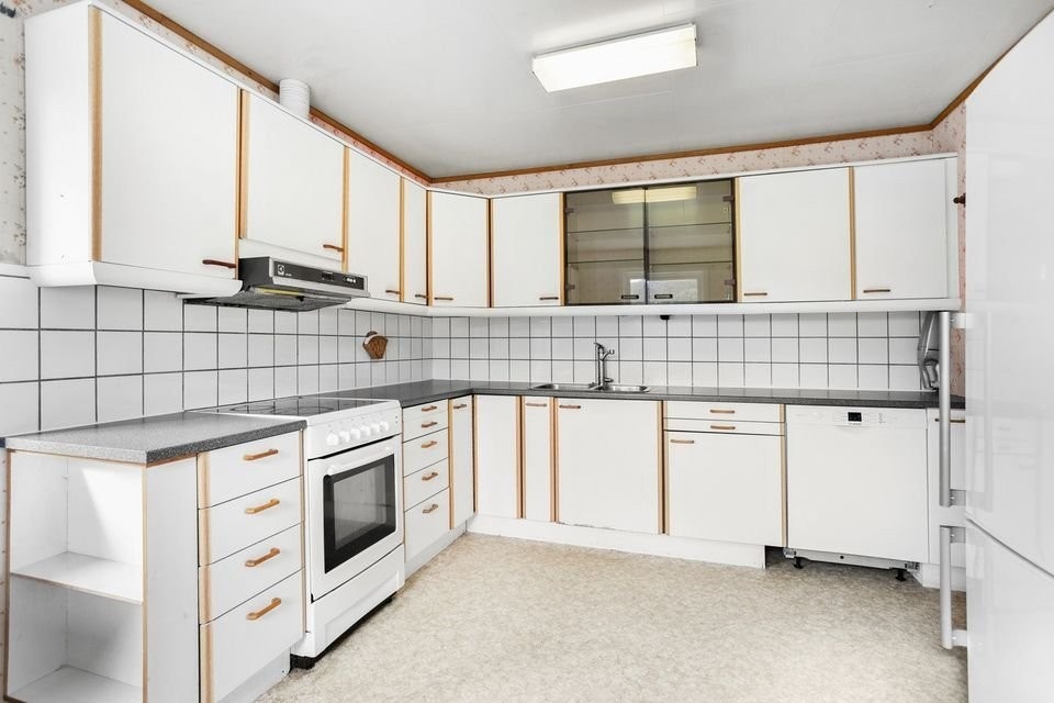 Kjøkken i L-form med glatte fronter og benkeplate i laminat. Inkluderer opplegg for oppvaskmaskin. Galleribilde