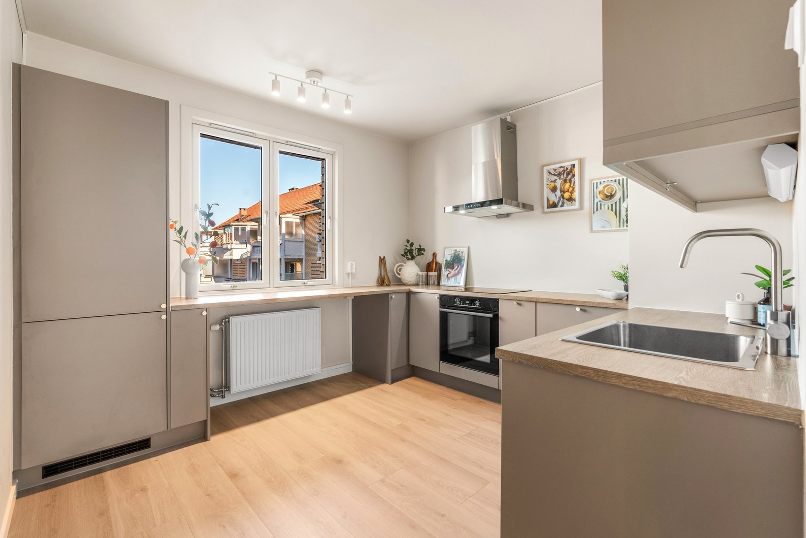 Kjøkkenet ligger i eget rom og fikk en ny, stilren innredning fra Norema i 2024, plassert i en romslig U-form. Under vinduet er det barløsning med mulighet for spiseplass. Galleribilde
