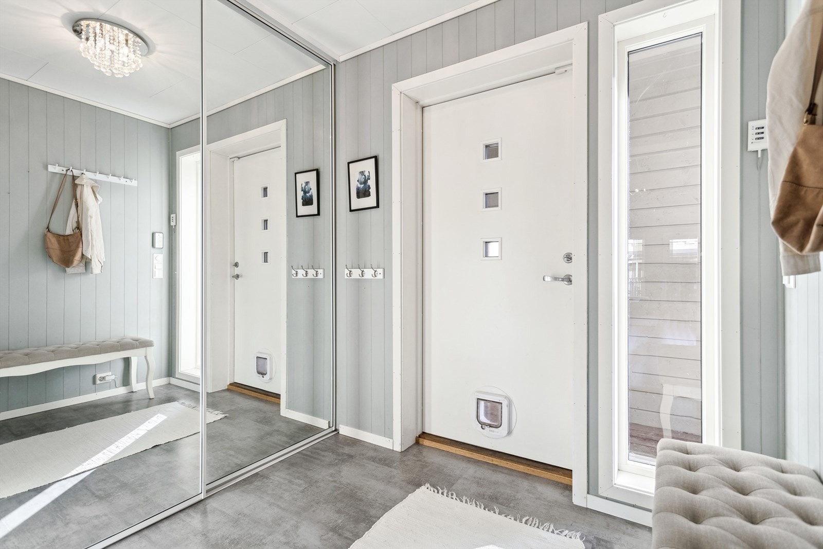 En skyvedørsgarderobe med speilfronter gir en forstørrende romeffekt. Ytterdøren har katteluke og et stort sidefelt. Galleribilde