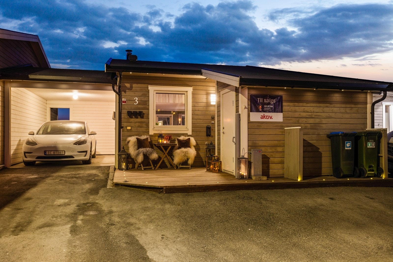 Gårdsplassen er asfaltert og det er parkering i carport med elbillader. Galleribilde