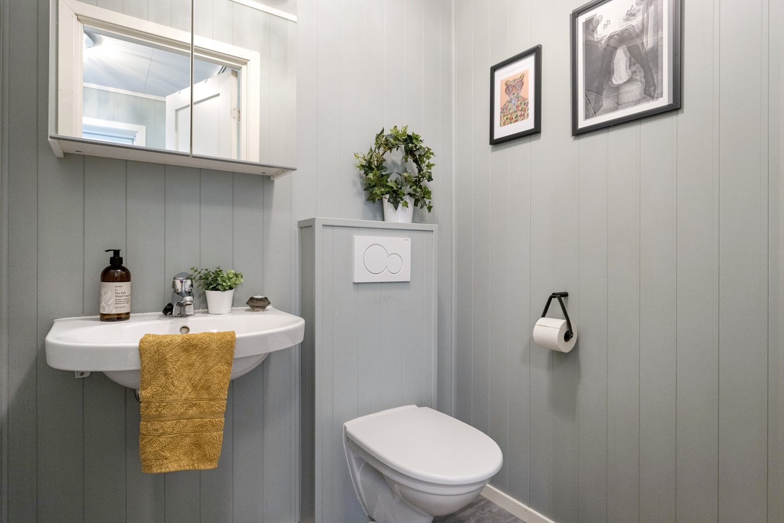 Boligen har wc-rom, bad og vaskerom. Wc-rommet har flislaminat på gulvet, vegghengt toalett, servant og speilskap. Galleribilde