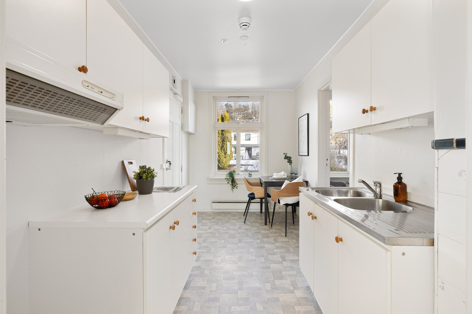 Lyst kjøkken med plass til et frokostbord under vinduet Galleribilde