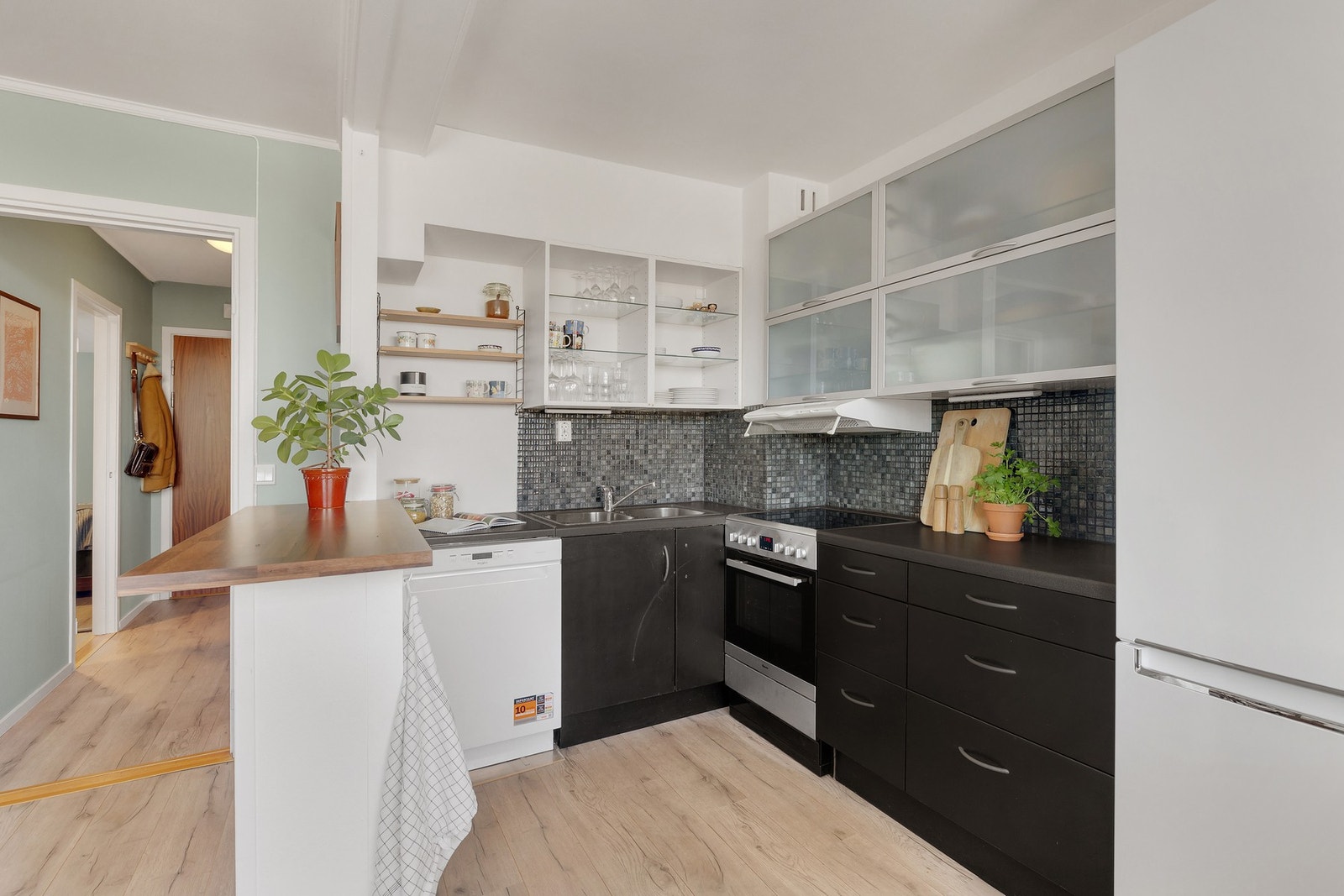 Kjøkkenet er innredet med glatte fronter på benkeskap. Galleribilde