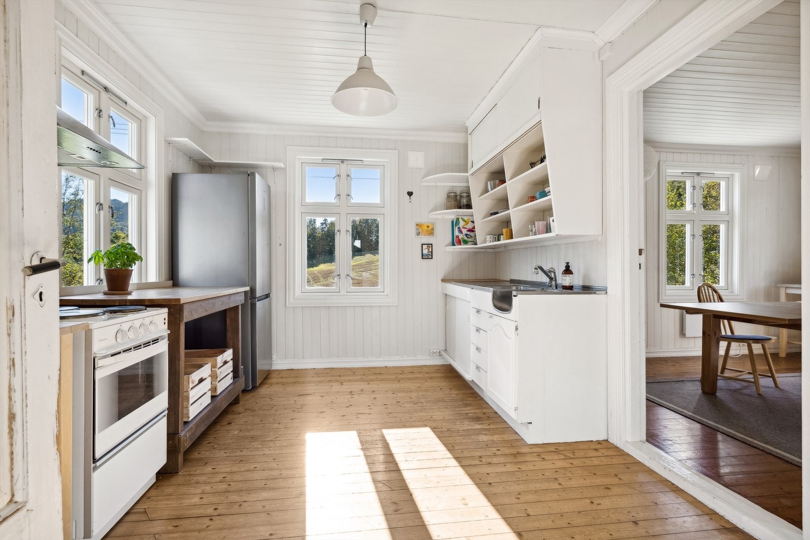 Kjøkkenet fremstår som lyst og luftig. Kjøkkenet inneholder en eldre plassbygget innredning med malte fronter, benkebeslag og heltre benkeplate. Galleribilde