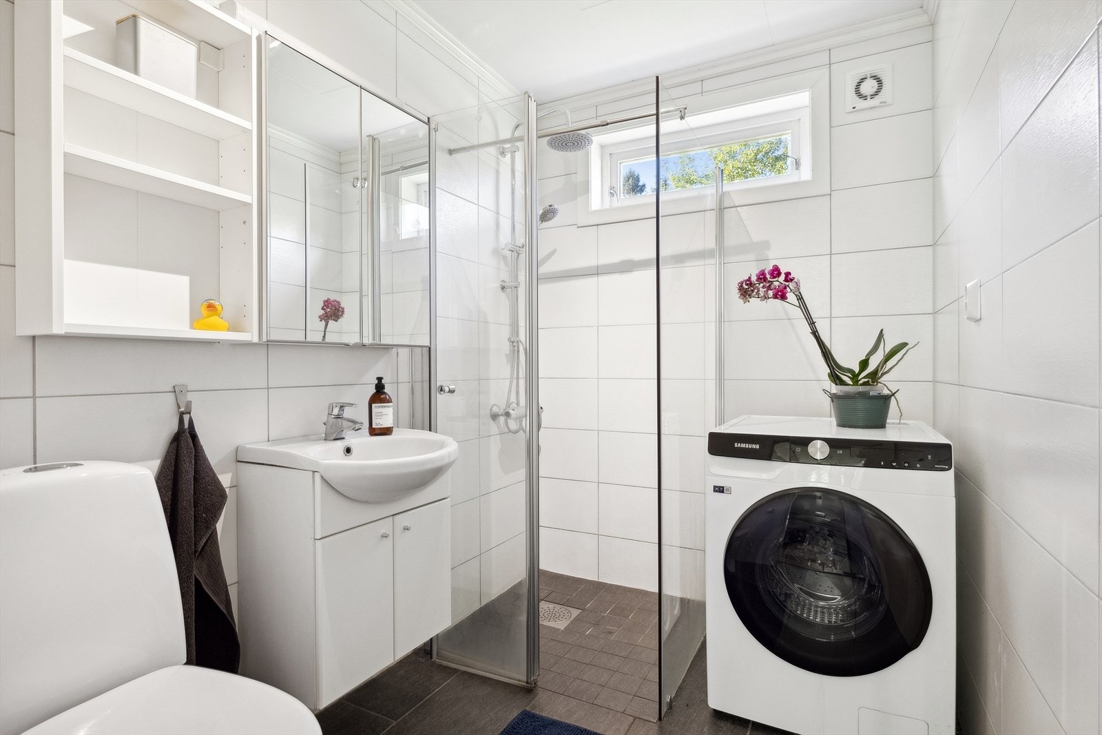 Badet ble totalrenovert i år 2013. Baderommet har flislagte gulv og vegger. Rommet er utstyrt med servantinnredning med porselensvask, toalett og veggmontert dusj. Det er opplegg til vaskemaskin. Varmekabler i gulv. Galleribilde