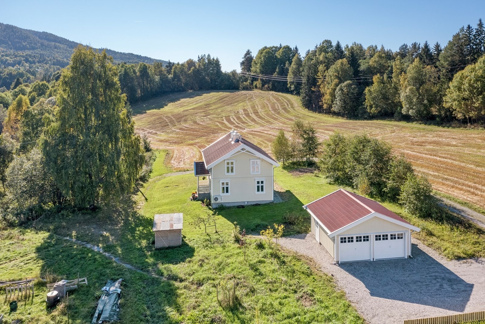 Landlig og lettstelt tomt med gruset innkjørsel. Galleribilde