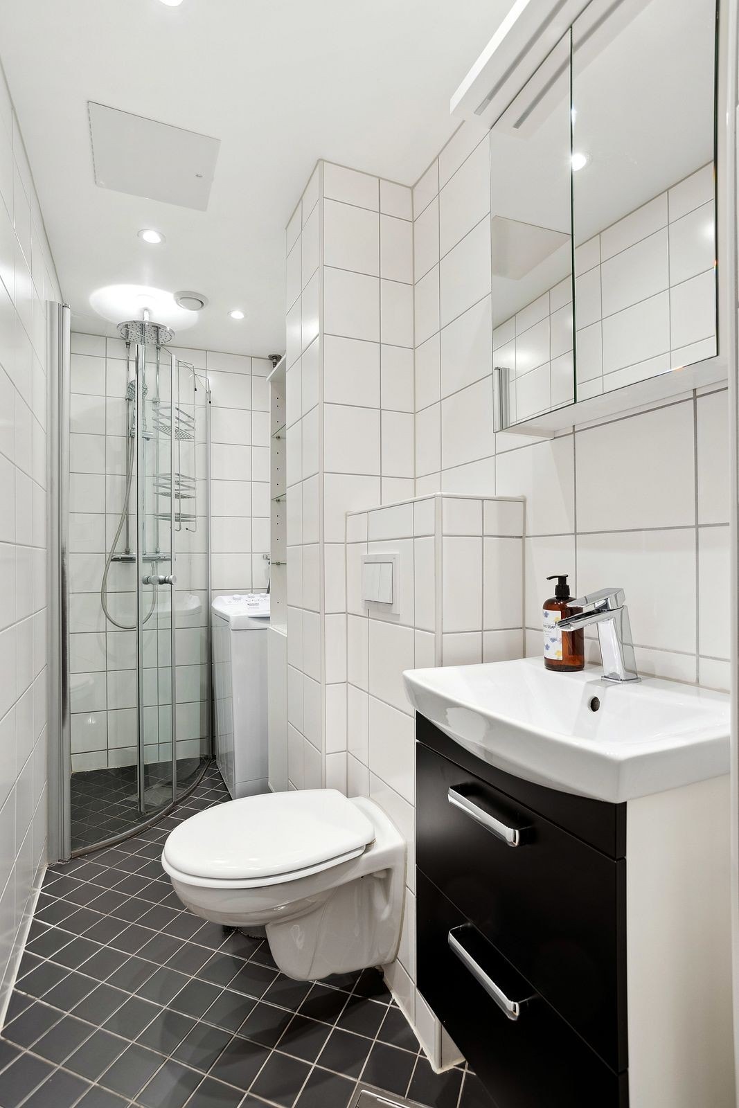 Flislagt bad med toppmatet vaskemaskin og varmekabler. Galleribilde