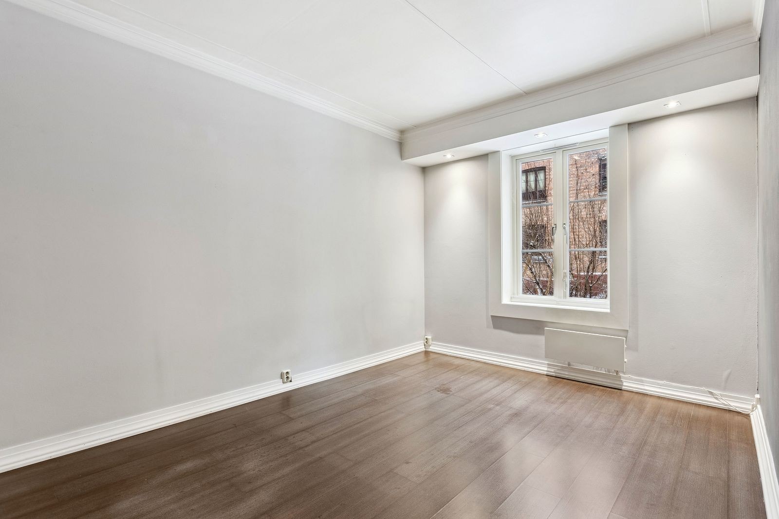 Romslig stue mot indre gårdsrom. varmekabler i gulv. Galleribilde