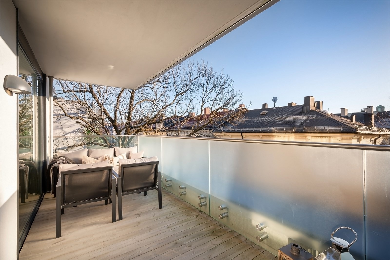 Terrasse har gulv av treverk med glass/metall rekkverk. Galleribilde