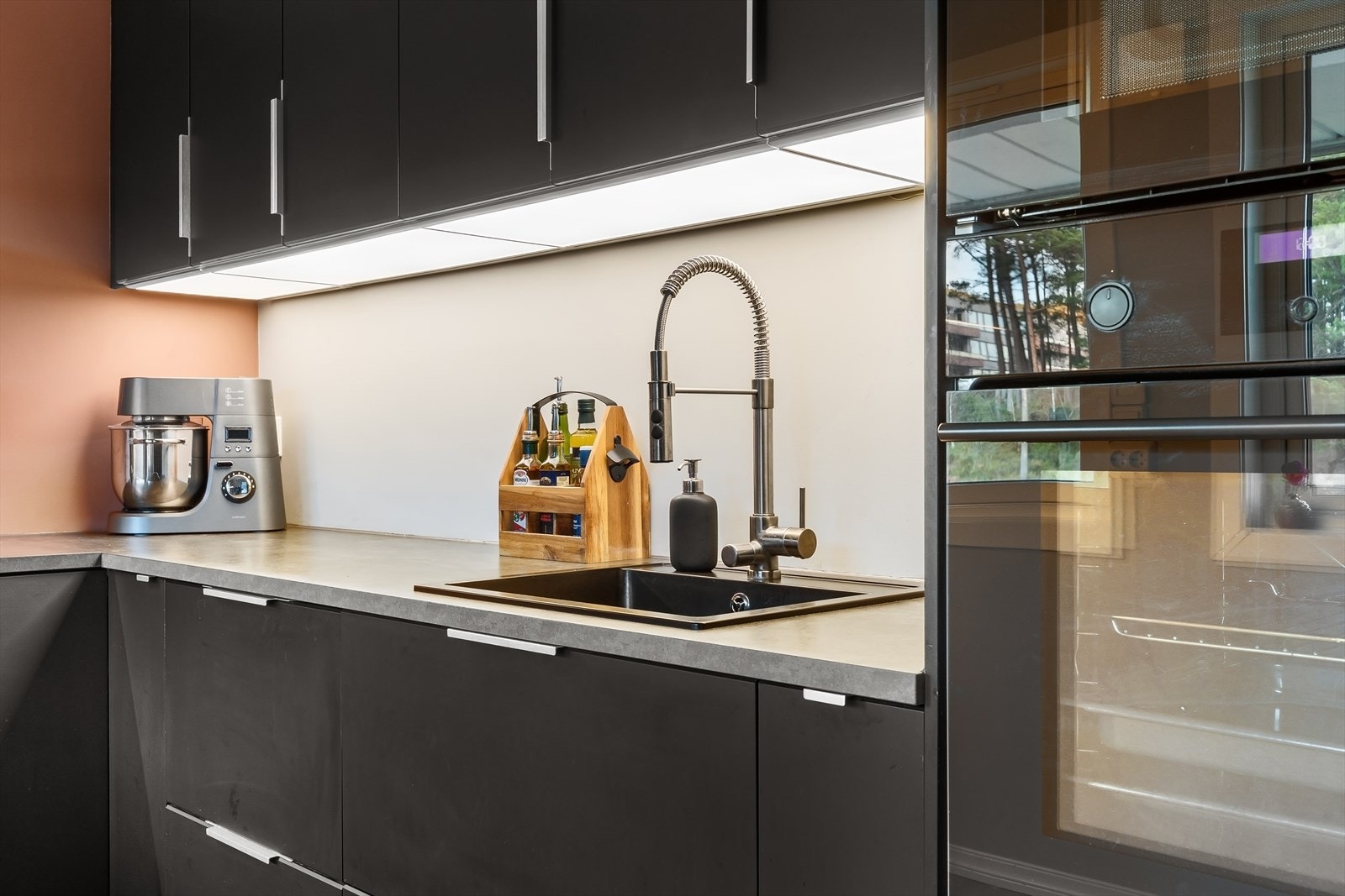 Moderne kjøkkeninnredning med fint lys på underside av overskap Galleribilde