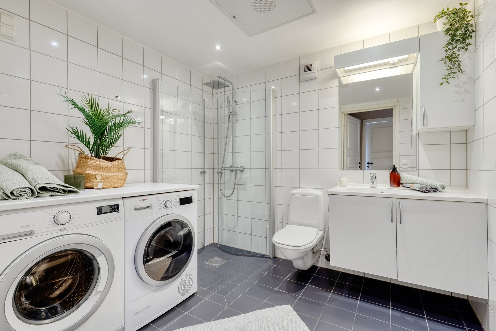 Pent, flislagt bad med gulvvarme. Badet har opplegg/plass til vaskemaskin og tørketrommel. Over maskinene er det montert en benkeplate. Galleribilde