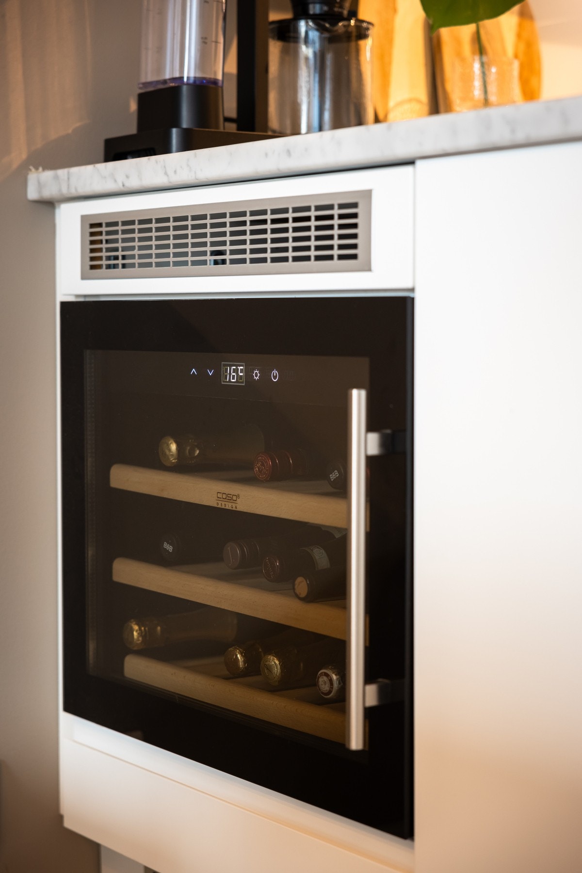 Integrert vinskap praktisk plassert i kjøkkeninnredningen en armlengdes avstand fra spisebordet. Galleribilde