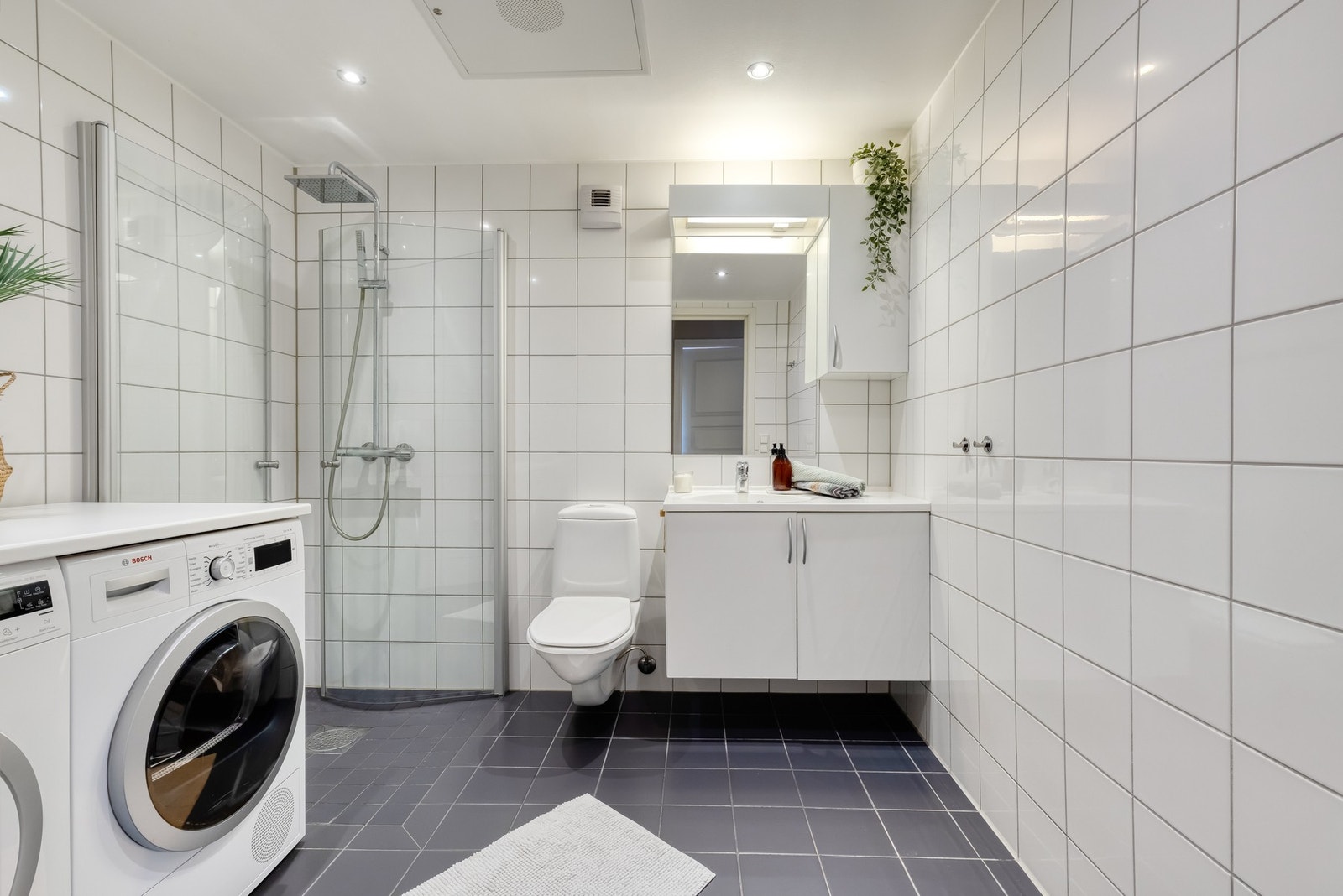 Badet er utstyrt med dusjhjørne, toalett og baderomsinnredning med nedfelt servant. Galleribilde