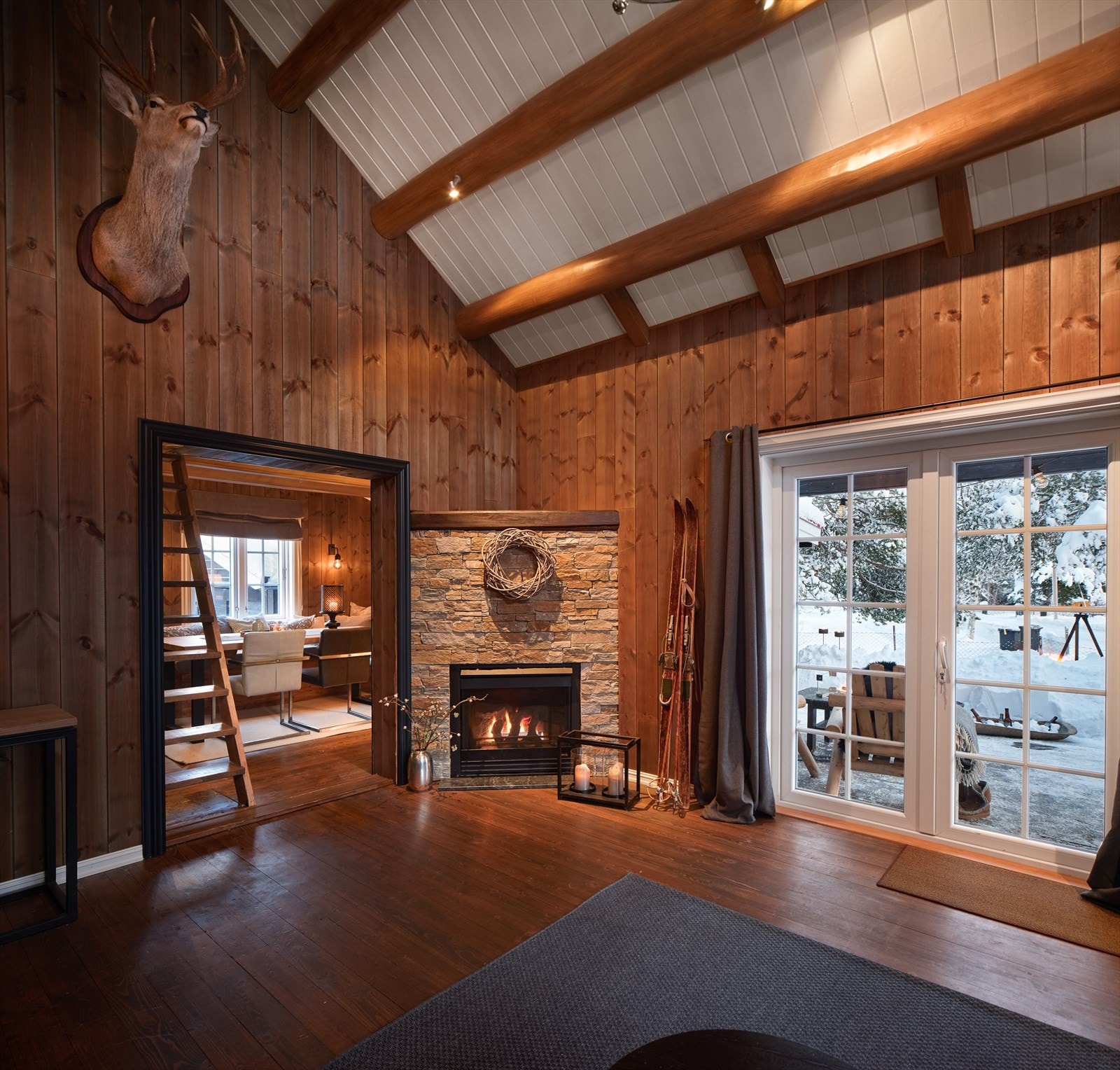 Gasspeis med naturstein, og beiset panel på vegger. Doble dører i glass til terrasse. Galleribilde