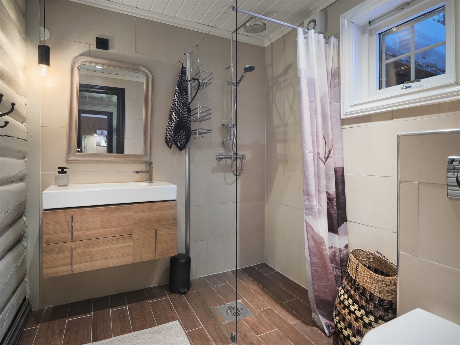 Lekkert bad med "trefliser" på gulv, fliser og tømmer på vegg. Varme i gulv og delikat innredning. Separat vaskerom i kjeller. Galleribilde