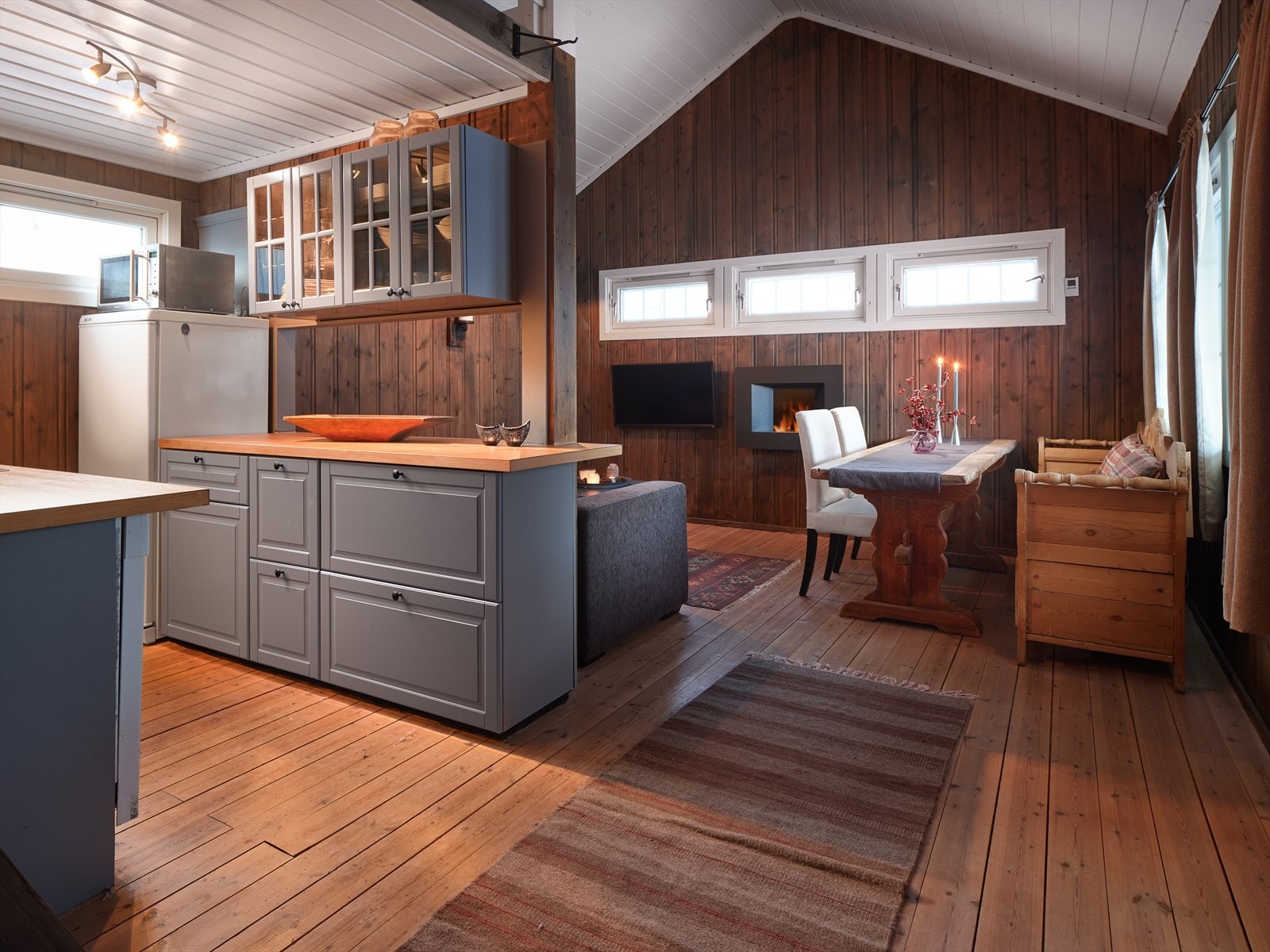 Åpen løsning mellom stue og kjøkken. Pent heltregulv med gulvvarme og beiset panel på vegger. Galleribilde